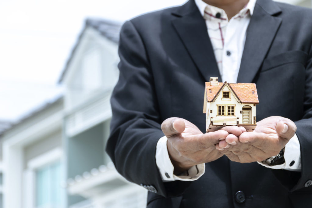 man holding model house