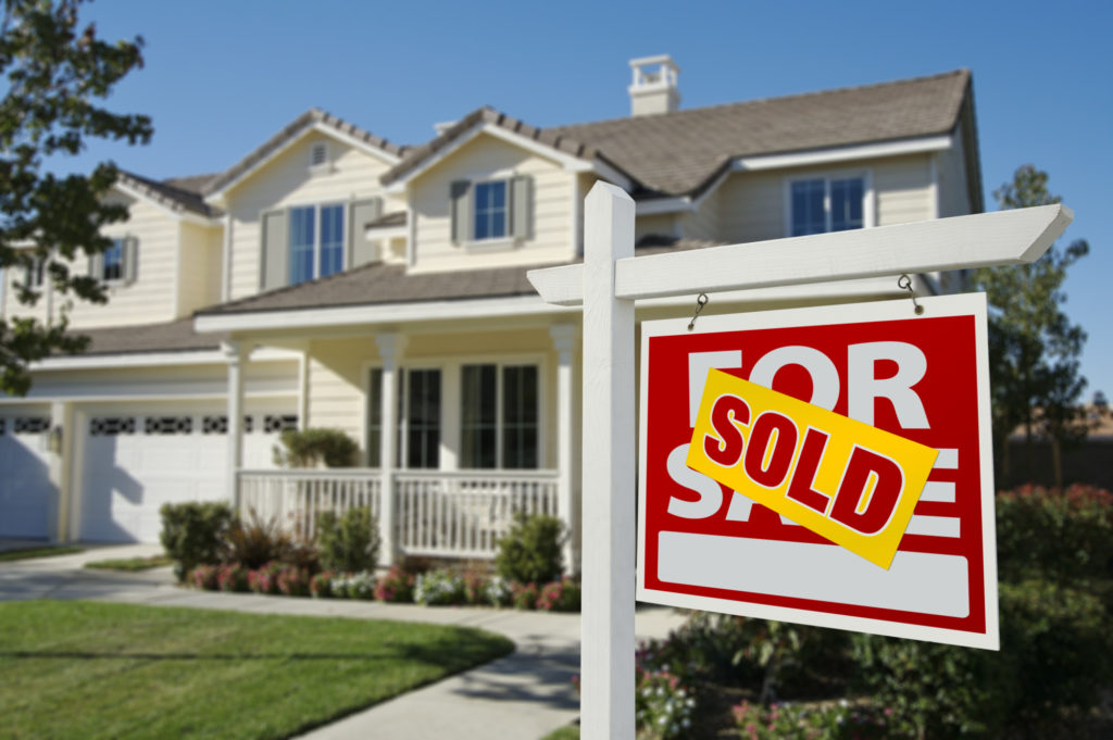 For Sale Sign Marked Sold in front of a House