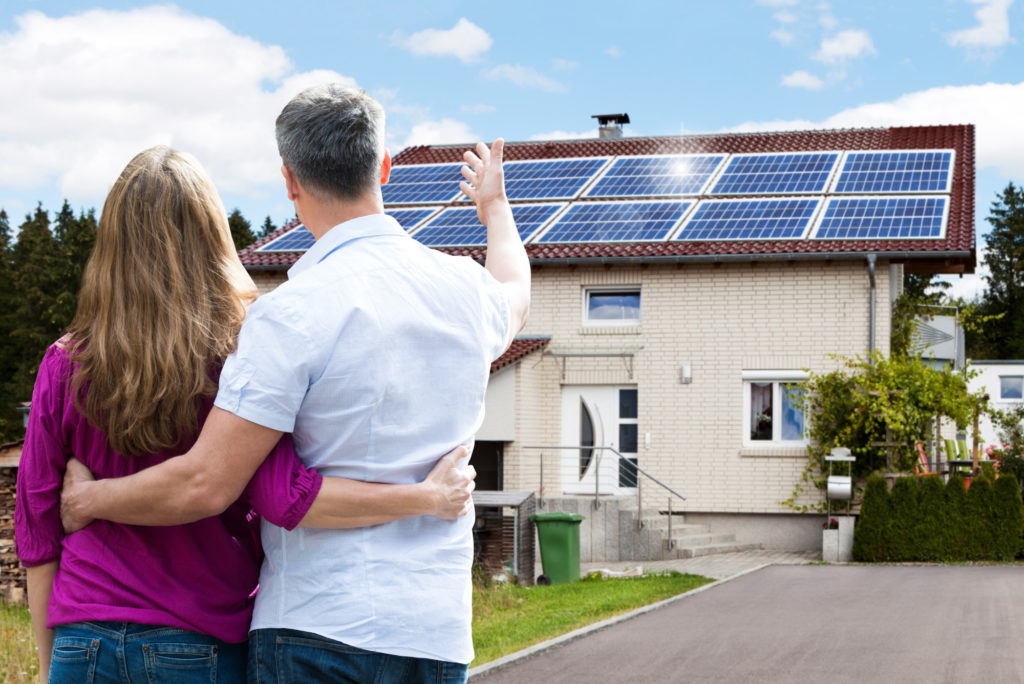 Couple Looking at Solar Panels on Their Home's Roof