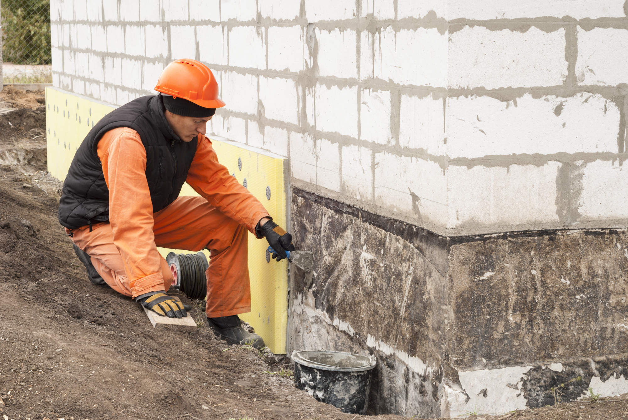 Рабочий положить. Foundation Repair. Фундамент стоковые фото. Фундамент утепление стоковое фото.